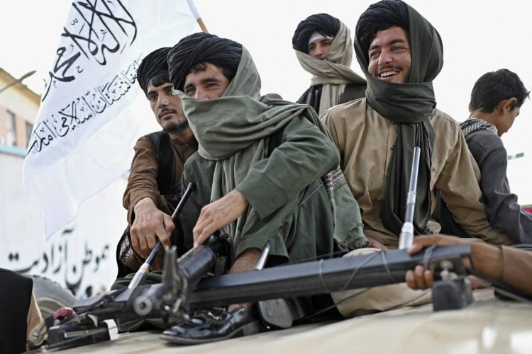 A group of armed Taliban fighters sitting on a vehicle. (Photo Credit: AFP)