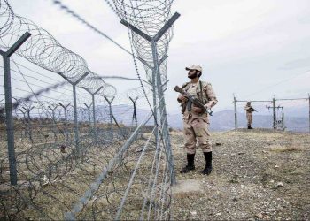 Iranian border guards stand near barbed wire at the Iran-Afghanistan border, amid ongoing concerns about a reported shooting incident involving Afghan refugees. (Photo Credit: Reuters)