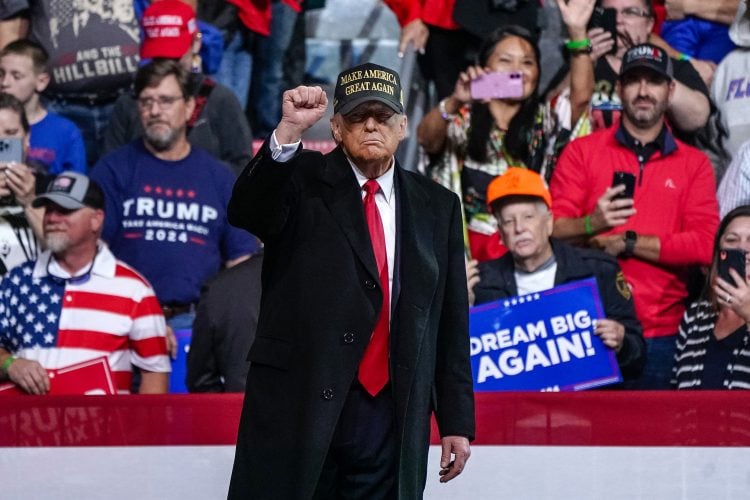Donald Trump raises his fist during an election campaign, symbolizing his defiant stance amid debates on U.S. policy toward the Taliban and Afghanistan’s future. (Photo Credit: Elijah Nouvelage / AFP)