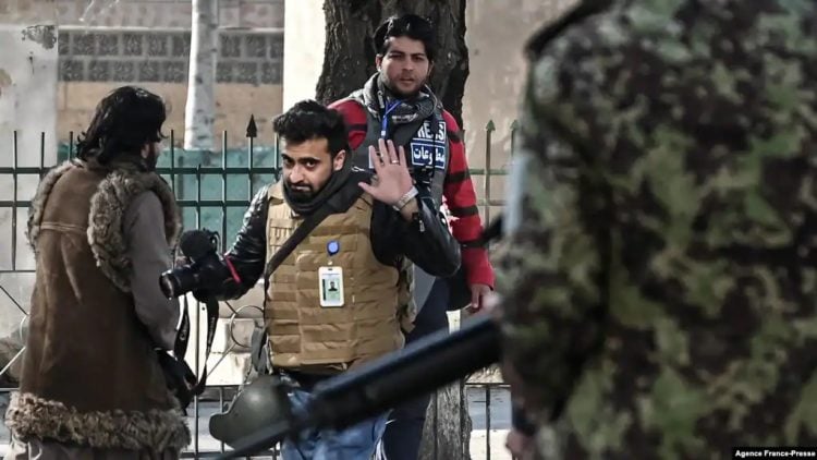 Under Taliban rule, Afghan journalists face relentless intimidation and censorship, risking their lives for press freedom. A journalist attempts to negotiate amid an escalating confrontation with Taliban fighters. (Photo Credit: Agence France-Presse)