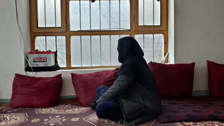An Afghan woman gazes out of her home, reflecting the isolation and challenges faced by women in Afghanistan under Taliban rule. (Photo Credit: 8am.media)