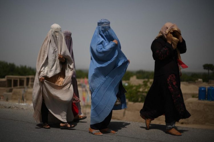 Despite escalating restrictions by the Taliban, Afghan women in traditional attire attempt to navigate public spaces in Herat, now largely off-limits to them. (Photo Credit: AFP)
