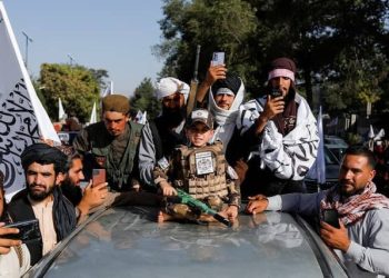 Taliban insurgents, including a child soldier, armed and draped in their flag, occupy a military vehicle amidst rising drug trade allegations. (Photo Credit: REUTERS | Representational Image)