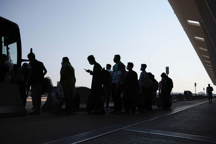 Afghan citizens, including skilled professionals, queue to board buses as part of mass emigration, highlighting the brain drain crisis in Afghanistan under Taliban rule. (Photo Credit: Anna Moneymaker/Getty Images)