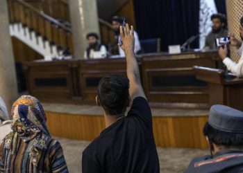 A journalist raises their hand to ask a question during a press conference with Taliban officials in Kabul, Afghanistan. (Photo Credit: Victor J. Blue/The New York Times)