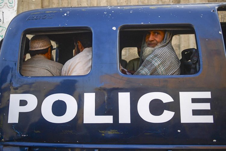 Afghan refugees arrested by Pakistani police are seen inside a police vehicle in Islamabad. (Photo Credit: Asif HASSAN / AFP)