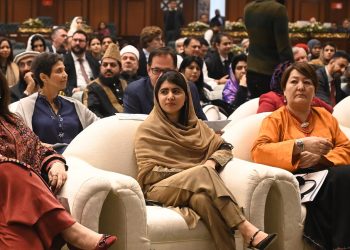 Malala Yousafzai, flanked by two women, at the OIC conference in Islamabad, with the audience in the background. (Photo Credit: AFP)