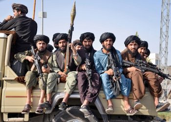 Taliban fighters are seen riding in the back of a vehicle in a show of force, highlighting the group's military presence in the region. (Photo Credit: Sanaullah SEIAM / AFP)