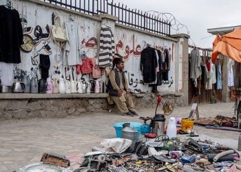 A street vendor sits beside his goods along a roadside in Kabul, amid Taliban restrictions limiting their operations after 4 p.m., as economic challenges persist. (Photo Credit: AFP)