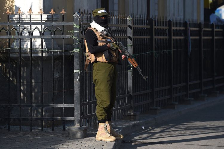 Taliban fighter guards a government building in Kabul. Photo Credit: AFP