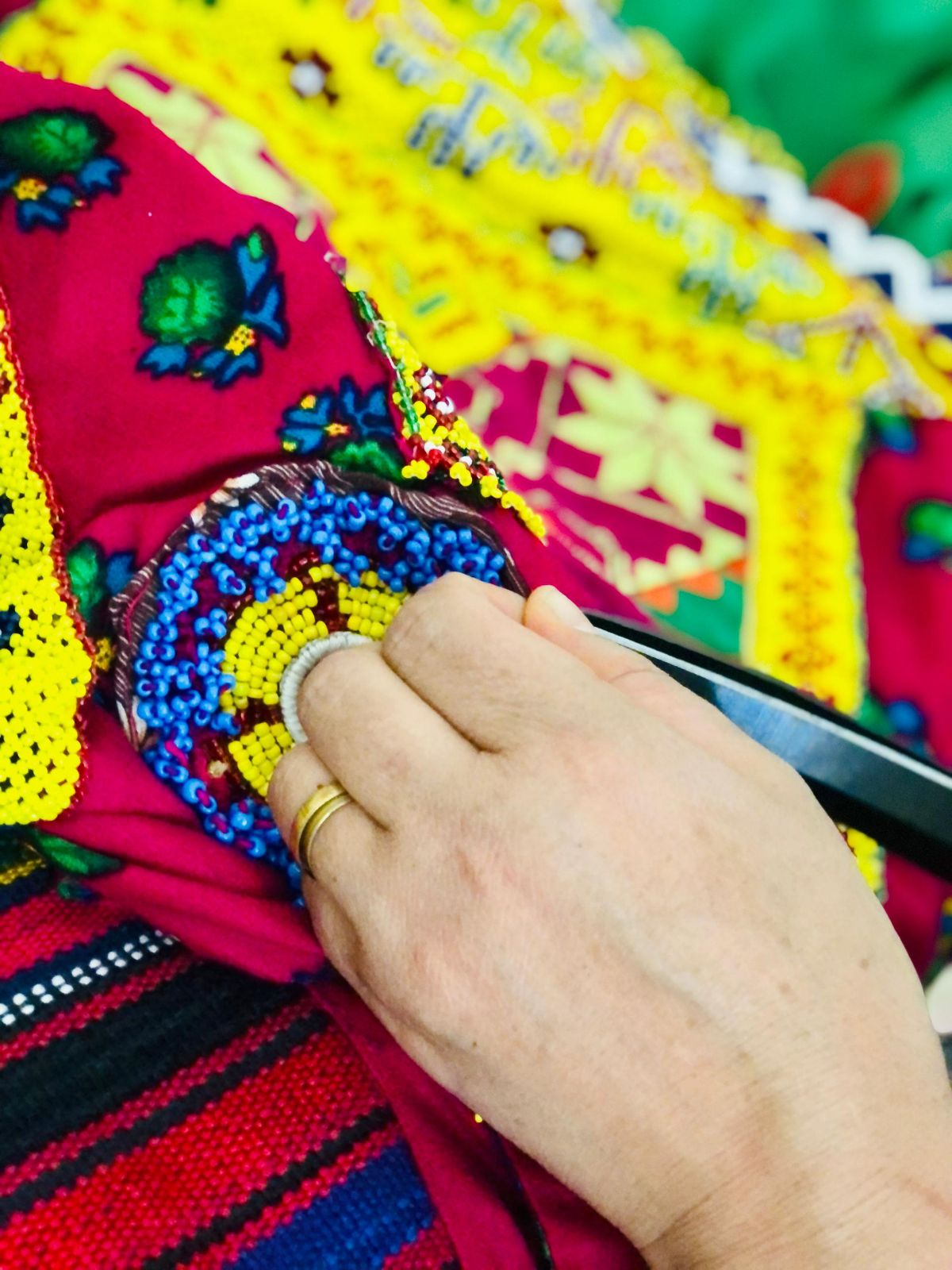 Artisan adds beadwork to a traditional garment for World Handicrafts Day. (Photo Credit: Exclusive)