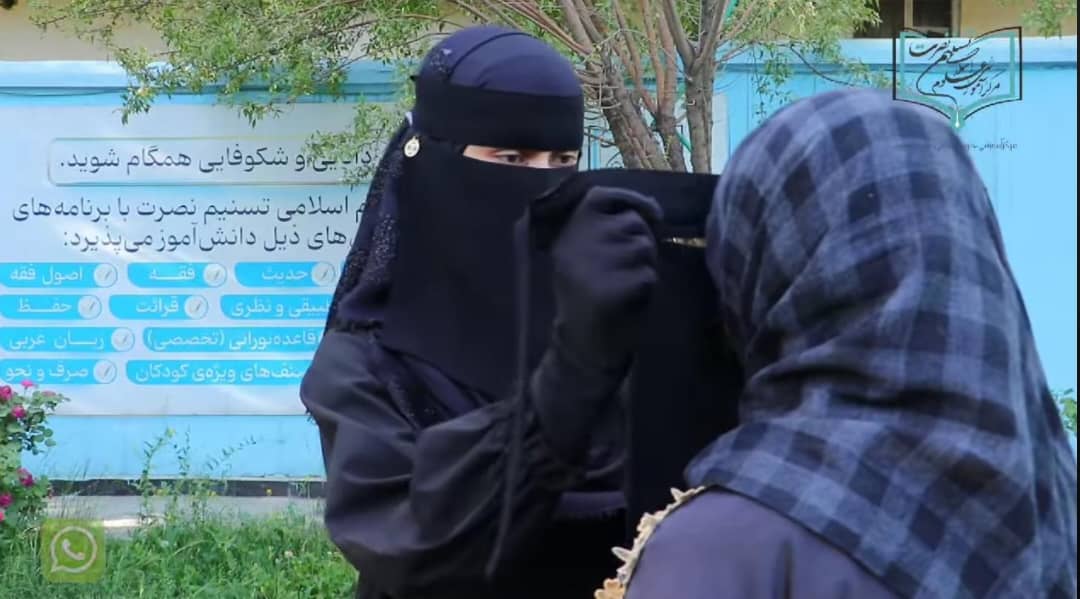 A woman in a burqa interacts with another at a Taliban-controlled madrasa, illustrating the strict dress code in place. (Photo Credit: Social Media)