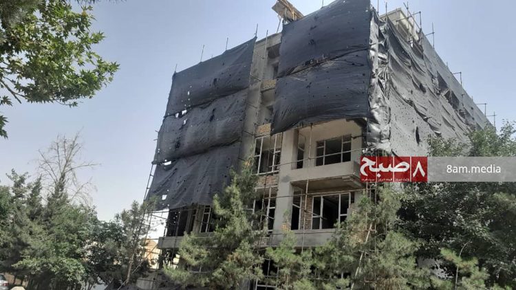 A partially constructed high-rise building in Taloqan stands covered in protective sheeting, halted amid ongoing disputes over construction permits. (Photo Credit: 8am.media)