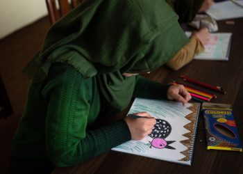 A girl in Afghanistan quietly sketches a colorful bird in her notebook — a fleeting moment of creativity in a world that keeps trying to silence her dreams. (Photo Credit: AFP)