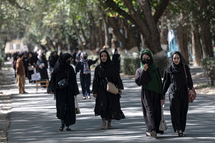 Women in Afghanistan walk along a tree-lined street in Kabul, dressed in traditional attire, as they navigate daily life under Taliban restrictions, June 2025. (Photo Credit: AFP)