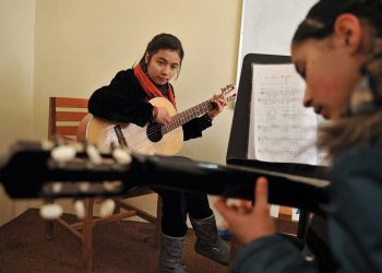 Young girls participate in a guitar lesson at a music school in Afghanistan, showcasing their passion for music before the Taliban's restrictions took effect. (Photo Credit: AFP)