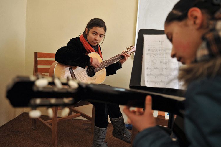 Young girls participate in a guitar lesson at a music school in Afghanistan, showcasing their passion for music before the Taliban's restrictions took effect. (Photo Credit: AFP)