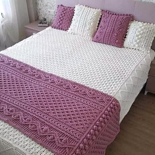 A beautifully crafted bed adorned with intricately crocheted white and purple bedding, showcasing traditional textile artistry. (Photo Credit: Exclusive)