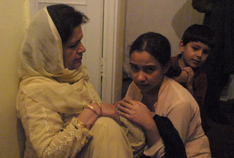 An elder shares a traditional story with attentive children in a warm, intimate setting. (Photo Credit: AFP)