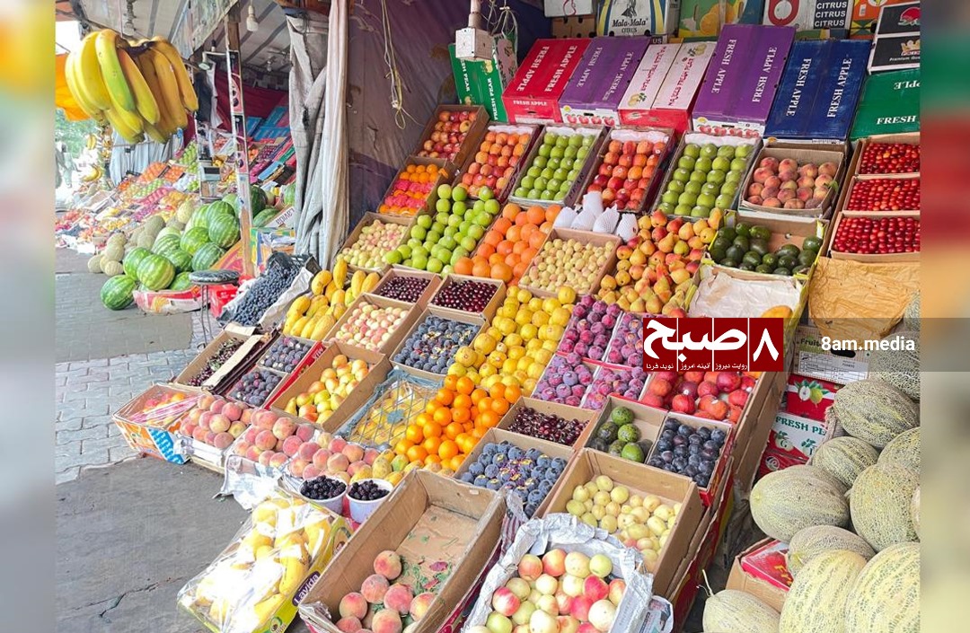 A vibrant fruit market in Afghanistan showcases a variety of produce, including watermelons and melons, amid challenges of low sales.