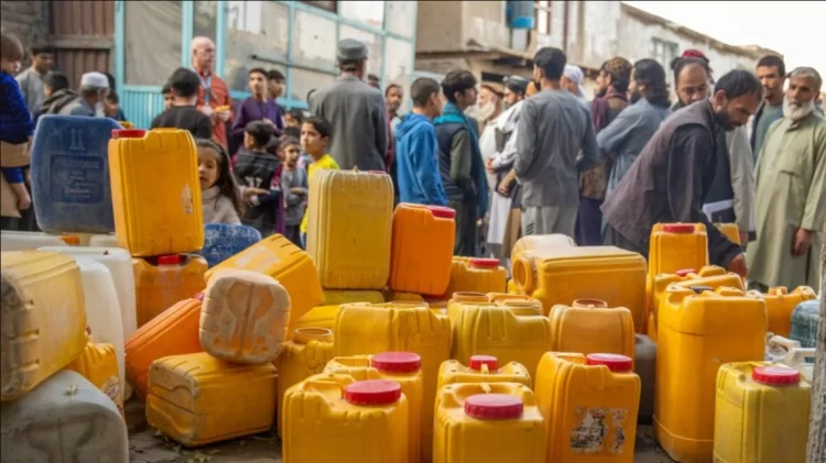 Residents of Kabul gather to purchase water from vendors amid a severe shortage, with yellow containers stacked as a symbol of the ongoing crisis. (Photo Credit: UNICEF)