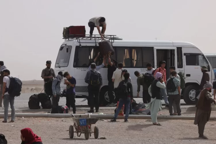 Afghan migrants loading belongings onto a bus during forced expulsion from Iran, July 2025. (Photo Credit: Marjan Wafa (IOM))