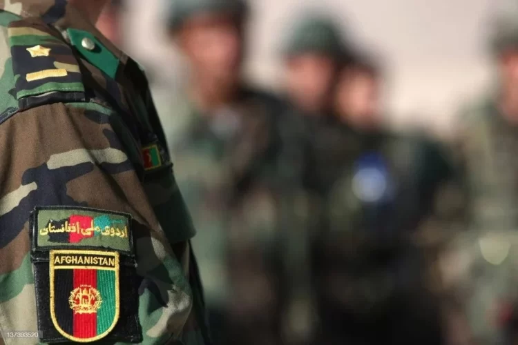 A close-up view of a military uniform featuring the Afghanistan national emblem, worn by a soldier, with other troops visible in the background. (Photo Credit: Getty Images)