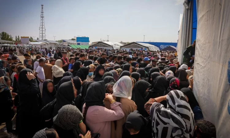 Hundreds of recently deported citizens of Afghanistan crowd outside a humanitarian aid center at the Islam Qala border crossing, seeking shelter and basic assistance. (Photo Credit: IOM)