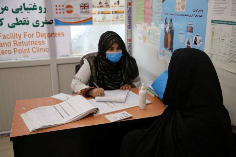 A healthcare worker at the UNFPA clinic in Nimruz provides medical consultation to a woman returning from Iran at the border facility that serves over 80 women daily. (Photo Credit: UNFPA)