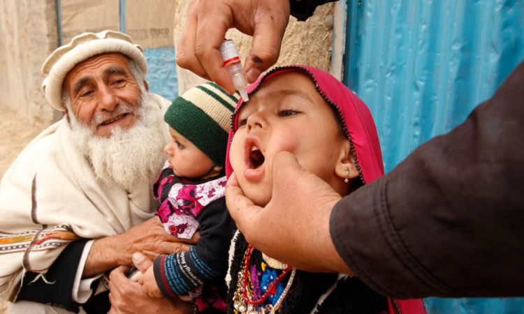 A health worker administers oral polio drops to a child in Afghanistan during a vaccination campaign. (Photo Credit: Reuters)