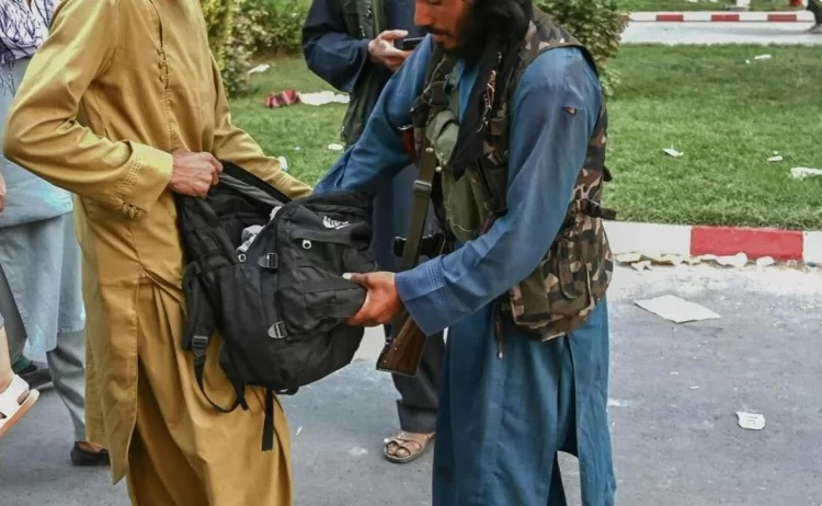 A Taliban fighter inspects a citizen's bag in Kabul, highlighting ongoing privacy concerns. (Photo Credit: Social Media)
