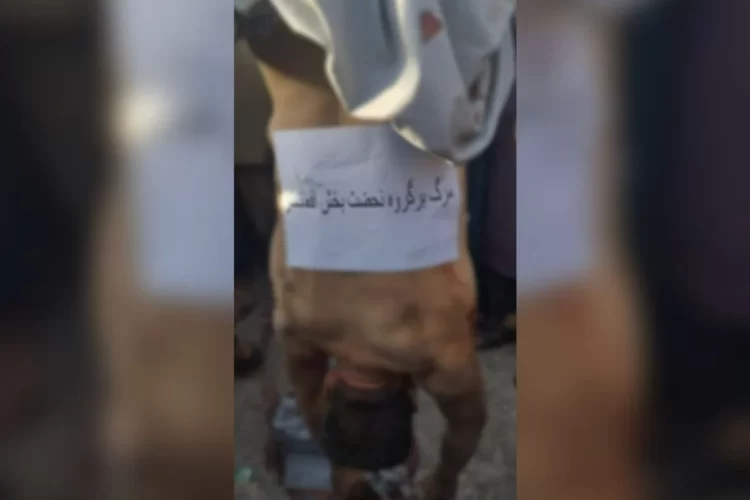The body of Dawood, executed by the Taliban, hangs from a tank barrel in Herat, with a sign reading "Death to the Afghanistan Liberation Movement," as crowds look on, highlighting the group's public brutality. (Photo Credit: Social Media)