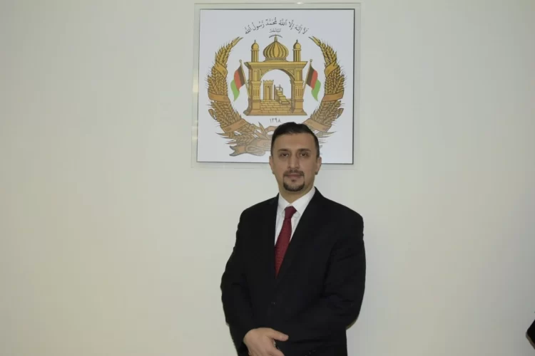 Naseer Ahmad Faiq during a formal engagement in front of Afghanistan’s national emblem. (Photo Credit: Exclusive)