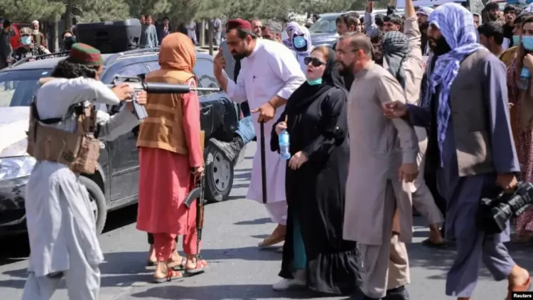 A Taliban fighter points a rifle at female protesters during a demonstration in Afghanistan. (Photo Credit: Reuters)