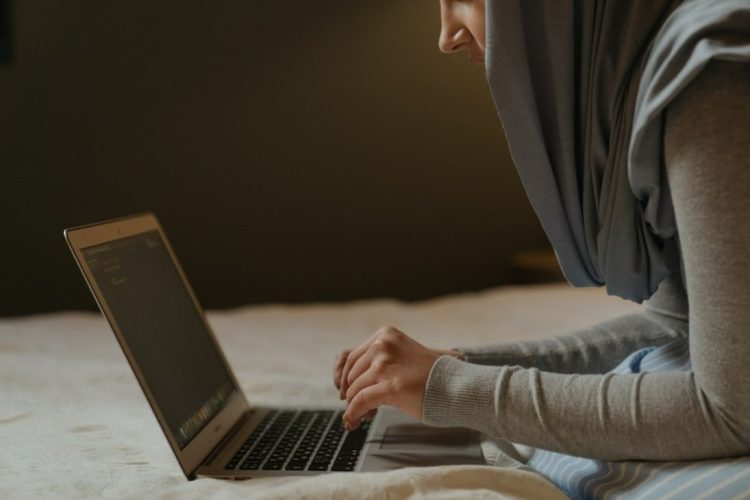 A woman works on her laptop in Afghanistan, representing the digital connectivity that has become a lifeline for education and economic opportunities, especially for women and girls who face restrictions in other spheres of life. (Photo Credit: MIT-Refugee)