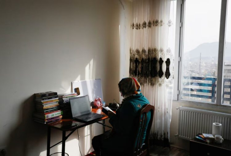 A young woman studies at home in Afghanistan as Taliban restrictions continue to limit educational and economic opportunities for women and girls. (Photo Credit: Reuters)
