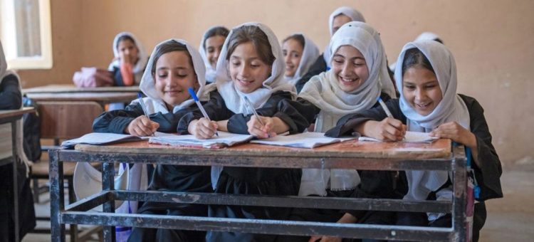 Girls attend school in a classroom in Afghanistan, working together on their studies before education restrictions were implemented. (Photo Credit: UNICEF)