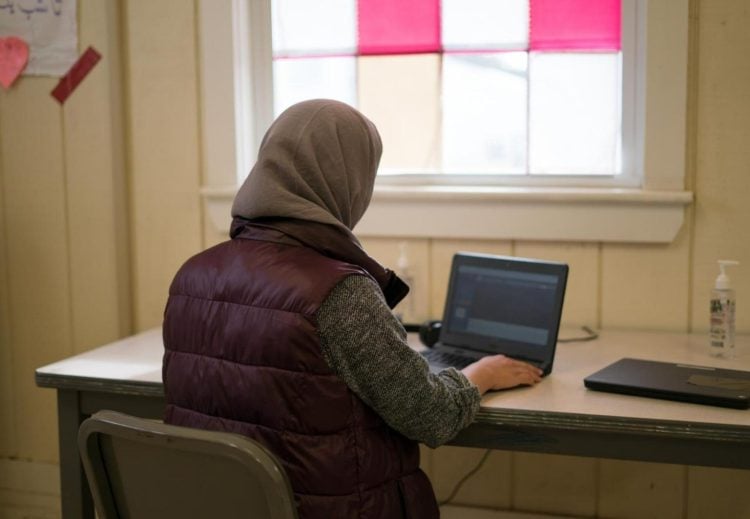 Woman works on laptop in Afghanistan despite Taliban restrictions limiting women's digital access and online entrepreneurship opportunities. (Photo Credit: Rescue)