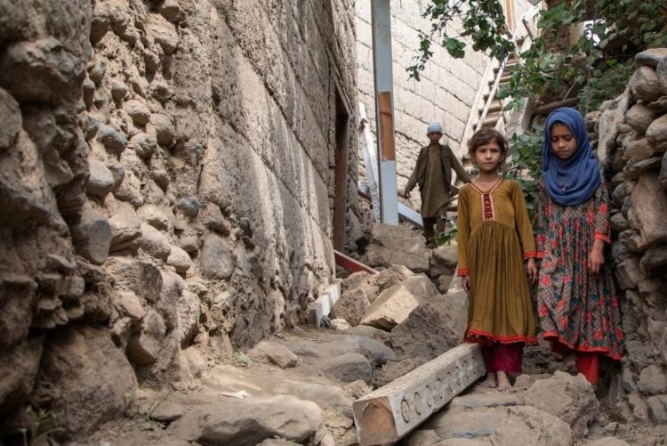 Two girls stand amid earthquake debris in Kunar province where over 4,000 homes were destroyed. (Photo Credit: UNICEF)