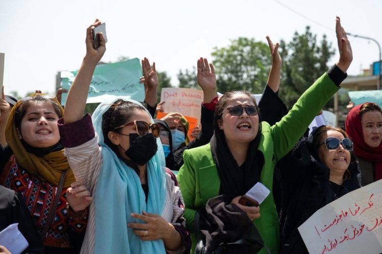Afghan women protesters raise their hands and hold signs demanding education and rights during a demonstration against Taliban restrictions on women's freedoms. (Photo Credit: Nava Jamshidi/Getty Images)