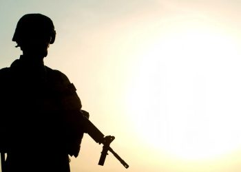 A silhouetted Afghan soldier stands guard during operations. Despite Taliban promises of amnesty, former security personnel who served alongside U.S. forces continue to face arrest, torture, and killings. (Photo Credit: CBS News)