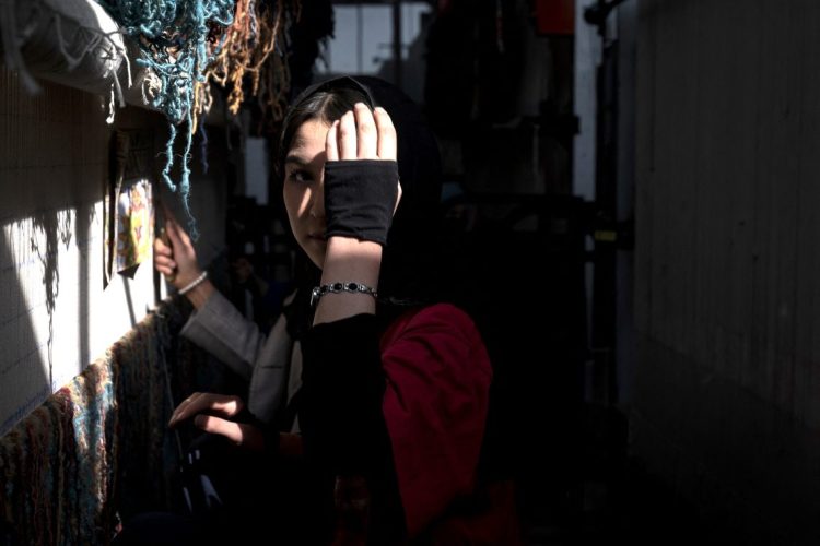 An Afghan woman shields her face in Kabul as the Taliban continue to impose severe restrictions on women's fundamental rights and freedoms across Afghanistan. (Photo Credit: AFP)