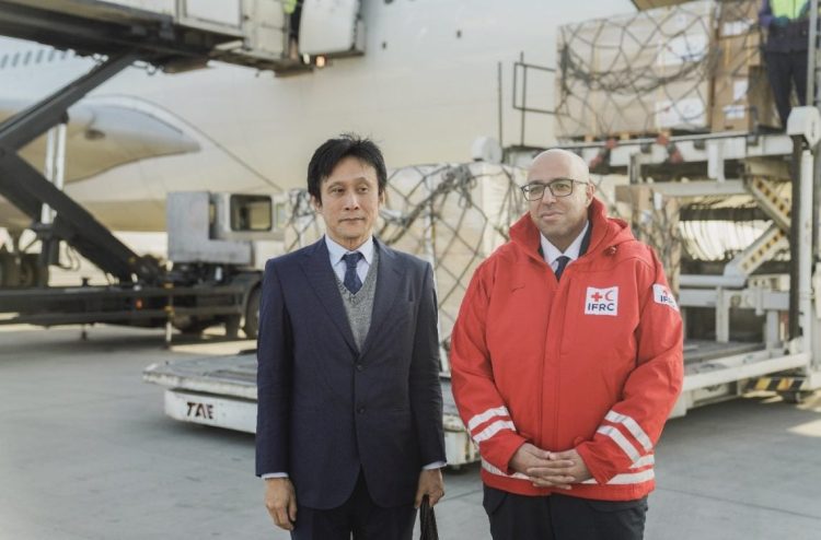 Japanese Ambassador Kenichi Masamoto and an IFRC representative stand beside emergency relief supplies at Kabul airport, destined for northern Afghanistan earthquake victims. (Photo Credit: @JapaninAFG/X)
