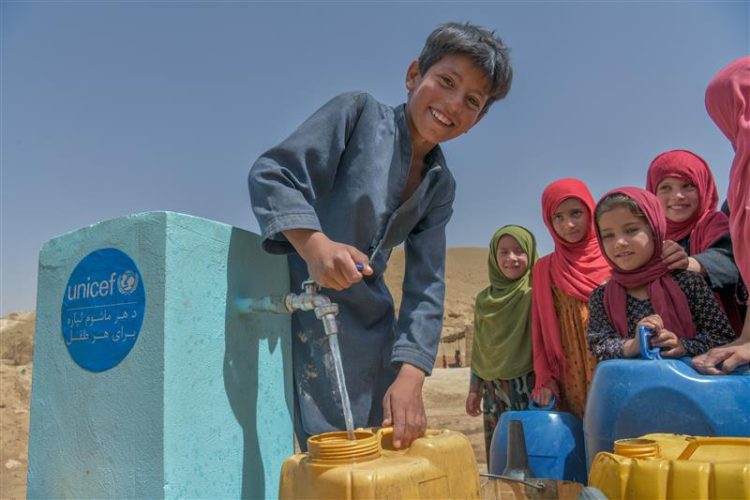 Children gather at a UNICEF water station to collect clean drinking water in Afghanistan, where prolonged drought threatens access to safe water for countless families. (Photo Credit: UNICEF)