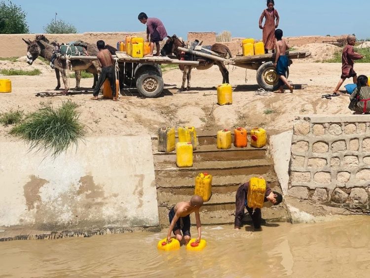 Children and families collect water from a community well in Afghanistan, where poor water management and rapid urbanization threaten public health and quality of life. (Photo Credit: UN-Habitat Afghanistan/F)