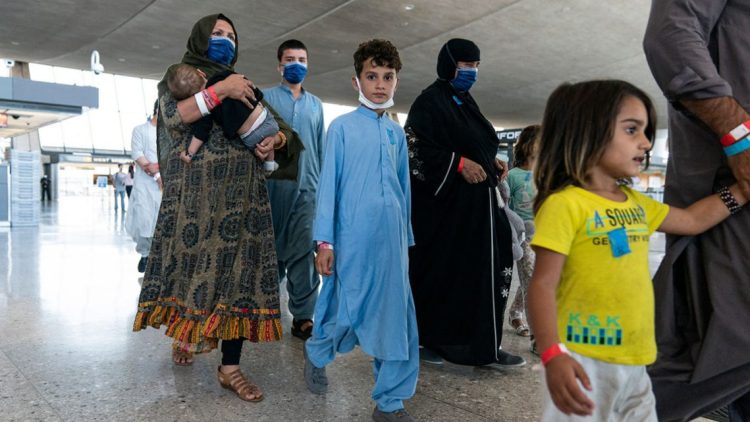 Afghan families, including children and infants, wait at an airport while processing asylum applications to Russia. Many Afghans have fled their country following the Taliban's return to power, seeking safety and better opportunities abroad. (Photo Credit: Joshua Roberts / Getty Images via AFP)