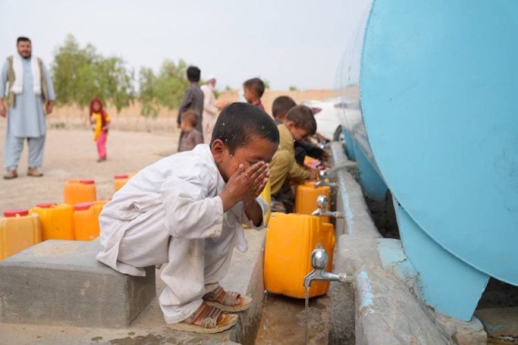 Children in Afghanistan collect water from a public tap amid severe water scarcity affecting millions across the country. The UN reports that eight out of every ten Afghanistan citizens lack access to clean drinking water. (Photo Credit: UN-Habitat)