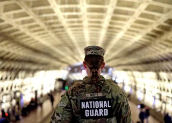 A U.S. National Guard member stands watch at a transit station, following increased security measures after the tragic shooting incident involving Afghan national Rahmanullah Lakanwal. (Photo Credit: GETTY IMAGES VIA AFP)
