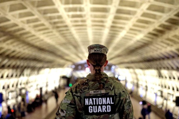 A U.S. National Guard member stands watch at a transit station, following increased security measures after the tragic shooting incident involving Afghan national Rahmanullah Lakanwal. (Photo Credit: GETTY IMAGES VIA AFP)