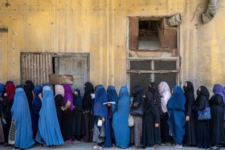 Women wait in line for humanitarian aid distribution in Afghanistan amid severe food insecurity crisis affecting millions. (Photo Credit: AP)